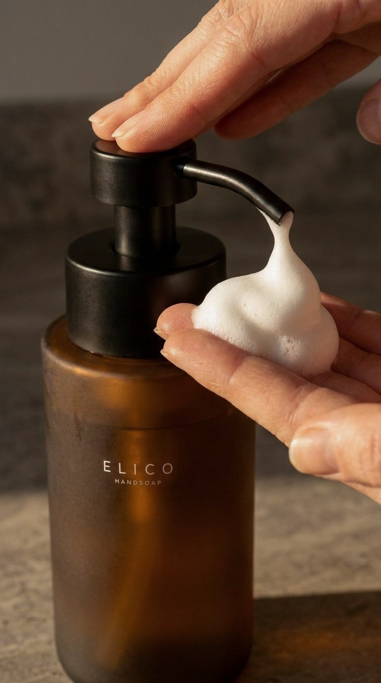 Close-up of a hand taking foam from an amber glass dispenser