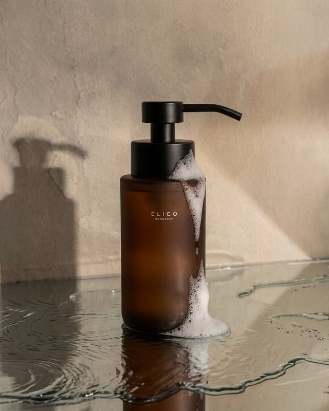 Dispenser i bärnstensglas med skum på en våt skiva
