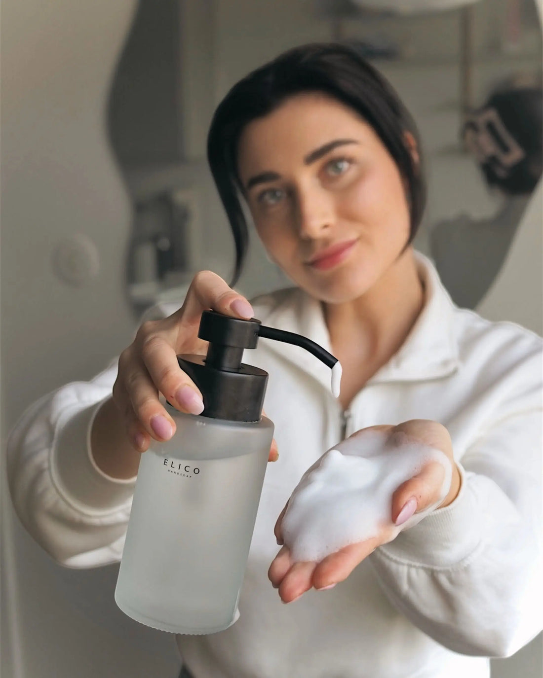 Woman with a frosted dispenser and foam in her hand
