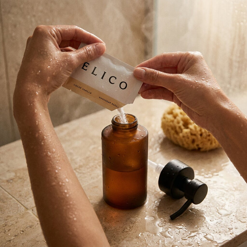 Hands pour a refill into an amber bottle